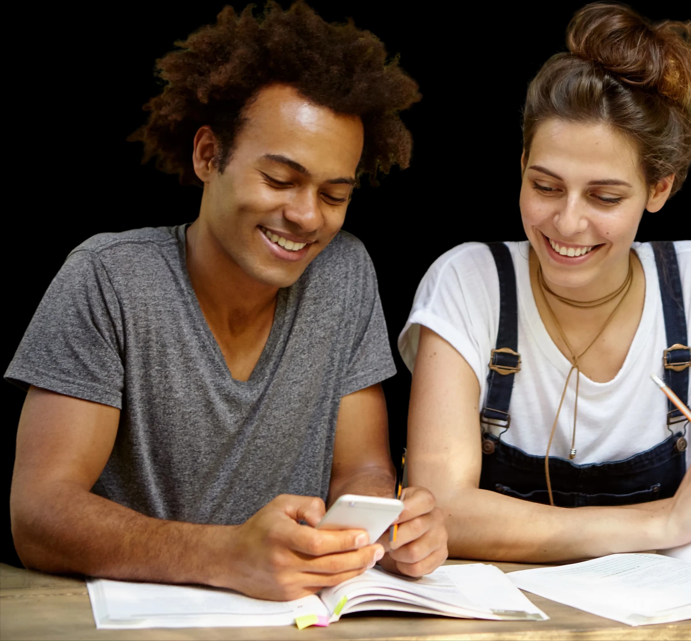 Dos estudiantes de Grado Medio de FP online estudiando juntos con apuntes y móvil
